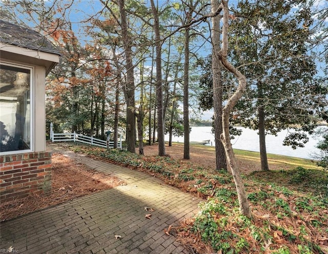 view of yard with a water view and a patio