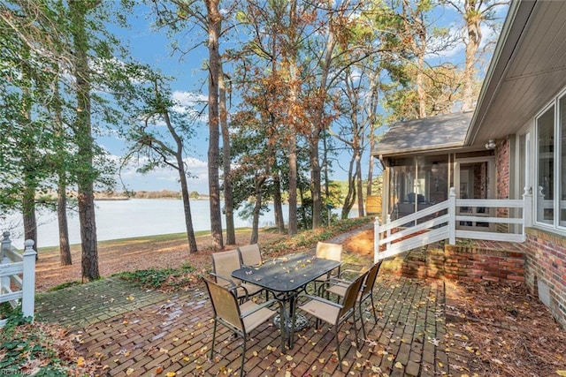 view of patio / terrace with a sunroom and a water view