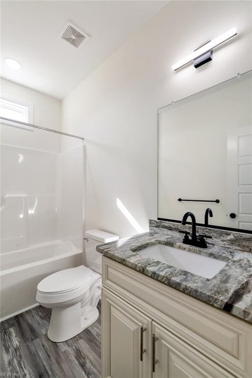 full bathroom with wood-type flooring, vanity, toilet, and shower / washtub combination