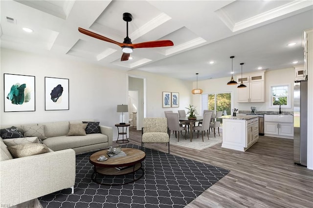 living room featuring ceiling fan, sink, coffered ceiling, dark hardwood / wood-style flooring, and beamed ceiling