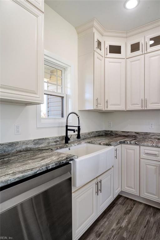 kitchen with dishwasher, sink, dark hardwood / wood-style floors, dark stone countertops, and white cabinetry