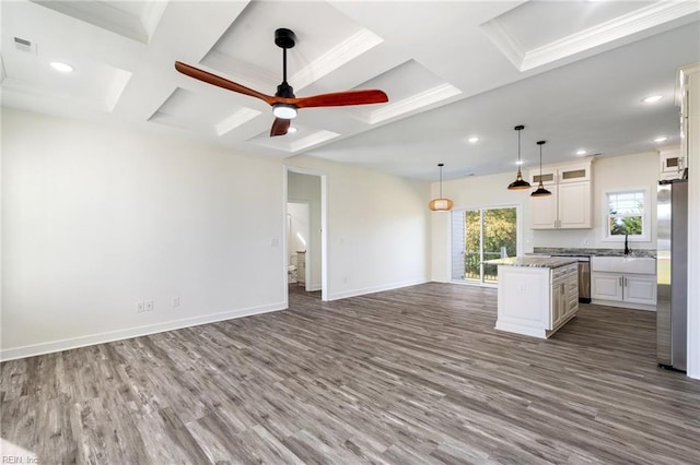 kitchen with appliances with stainless steel finishes, coffered ceiling, a kitchen island, pendant lighting, and white cabinetry