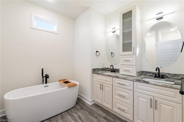 bathroom with wood-type flooring, vanity, and a bathing tub