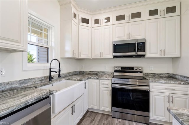 kitchen featuring light stone countertops, sink, stainless steel appliances, light hardwood / wood-style flooring, and white cabinets