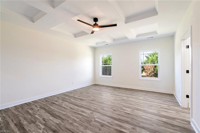 spare room featuring beam ceiling, light wood-type flooring, ceiling fan, and coffered ceiling