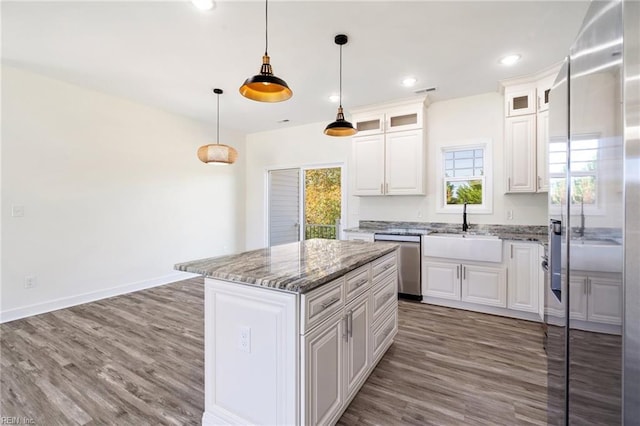 kitchen with white cabinets, sink, a kitchen island, and appliances with stainless steel finishes