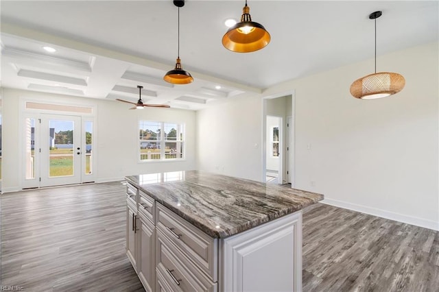 kitchen featuring coffered ceiling, ceiling fan, beam ceiling, pendant lighting, and wood-type flooring