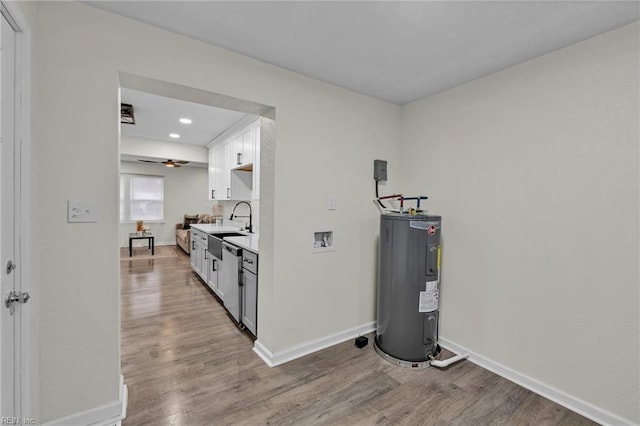 kitchen featuring ceiling fan, sink, water heater, white cabinets, and light wood-type flooring