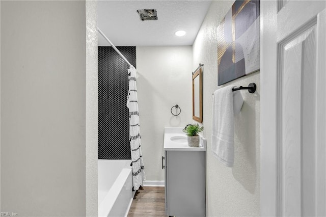 bathroom with vanity, shower / bath combination with curtain, and a textured ceiling