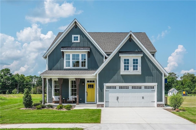 view of front facade featuring covered porch, a front yard, and a garage