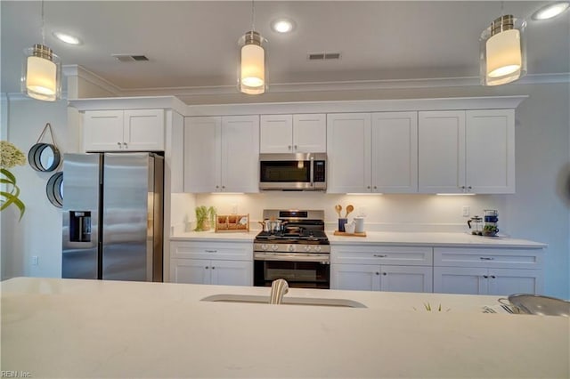 kitchen featuring pendant lighting, stainless steel appliances, and white cabinetry