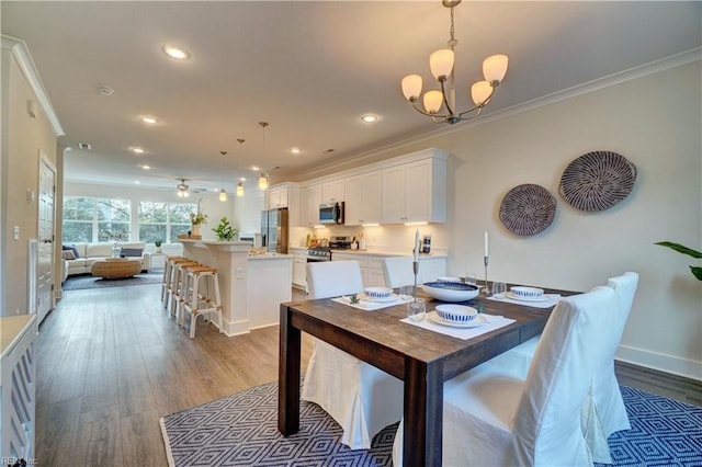 dining space featuring ceiling fan with notable chandelier, crown molding, and dark wood-type flooring