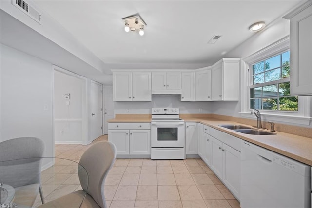 kitchen featuring white cabinetry, white appliances, sink, and light tile patterned floors