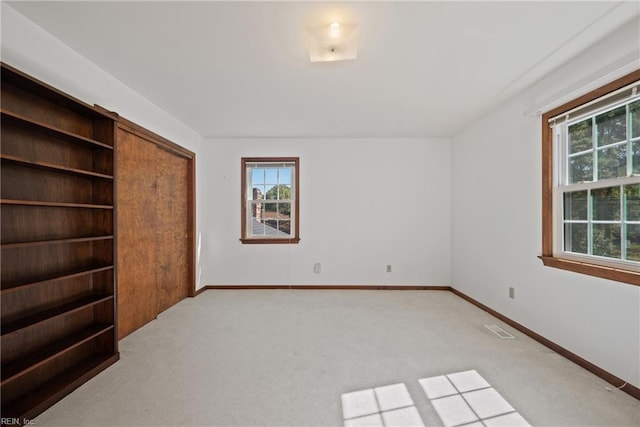 unfurnished bedroom featuring light carpet and a closet