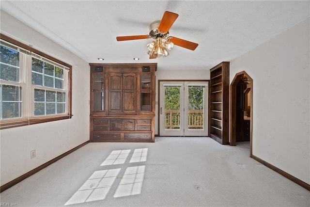 unfurnished living room with ceiling fan and light carpet