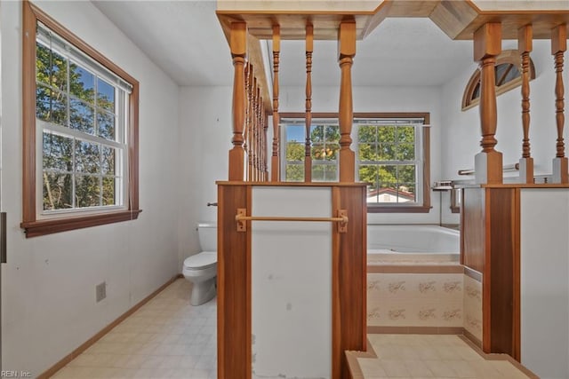 bathroom featuring a washtub and toilet