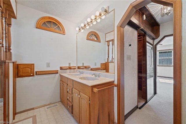 bathroom featuring a textured ceiling and vanity