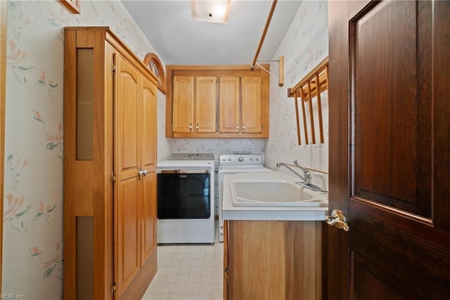 laundry room featuring washer and clothes dryer, cabinets, and sink