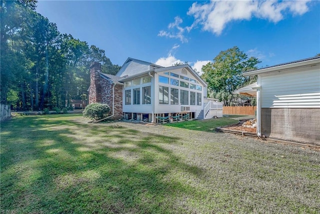 rear view of property with a yard and a sunroom