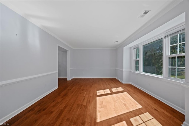 spare room with hardwood / wood-style flooring and crown molding