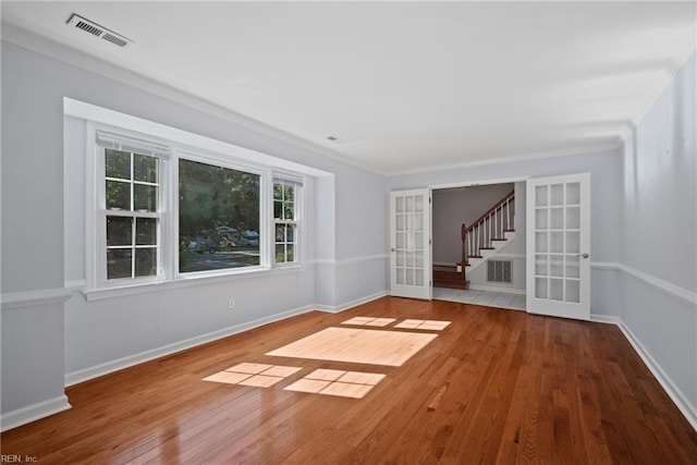 spare room with french doors, ornamental molding, and hardwood / wood-style floors