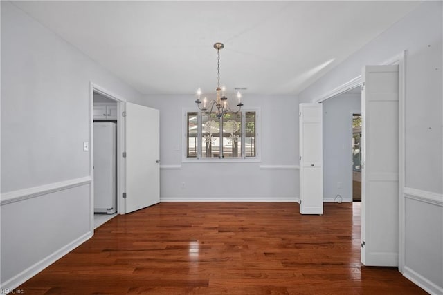 unfurnished dining area with dark hardwood / wood-style flooring and a chandelier