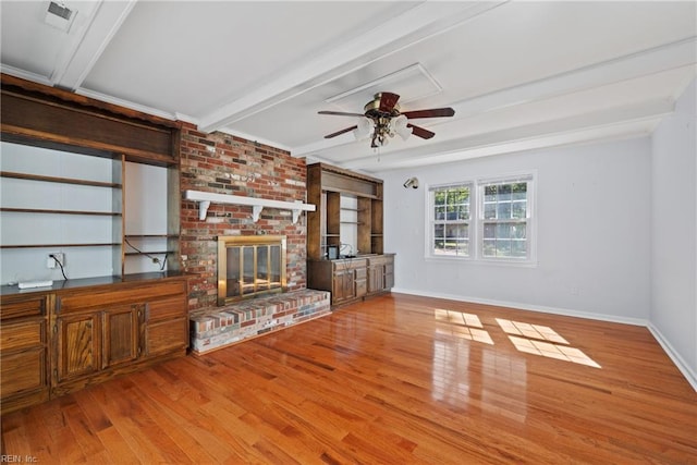 unfurnished living room with a fireplace, ceiling fan, light hardwood / wood-style flooring, and beamed ceiling