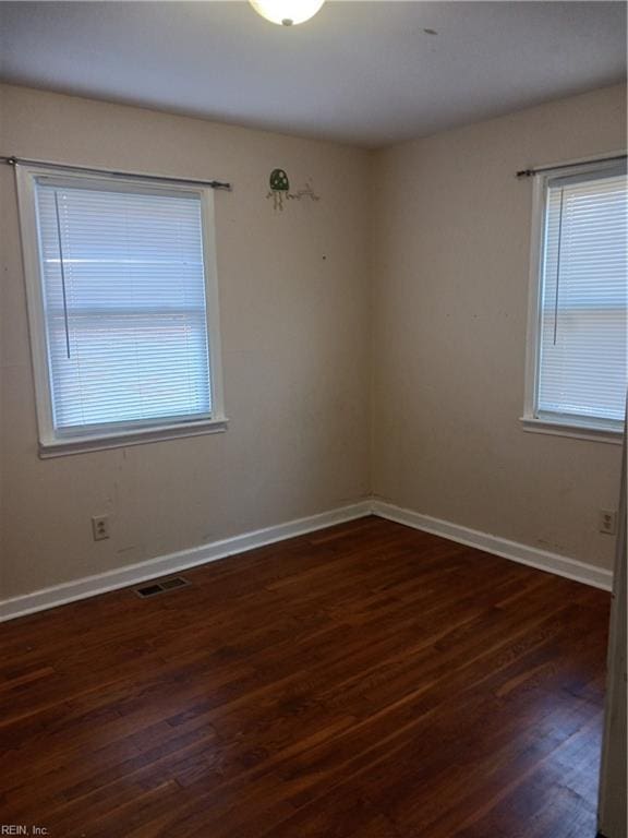 spare room with dark hardwood / wood-style floors and a wealth of natural light