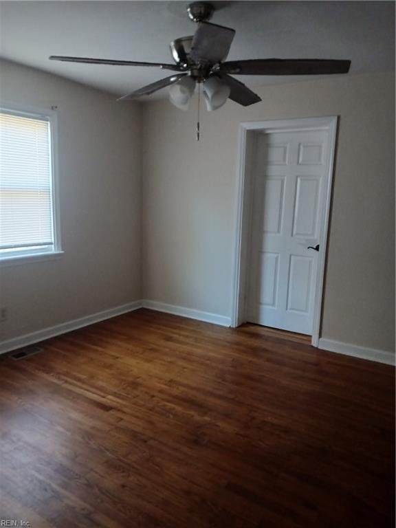 spare room with dark hardwood / wood-style floors and ceiling fan