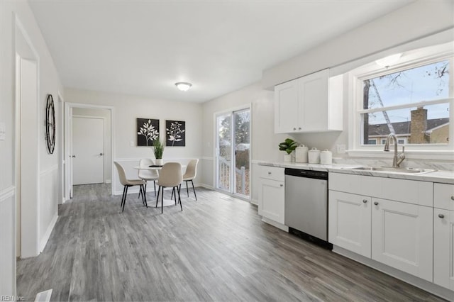 kitchen featuring white cabinets, dishwasher, wood-type flooring, and sink