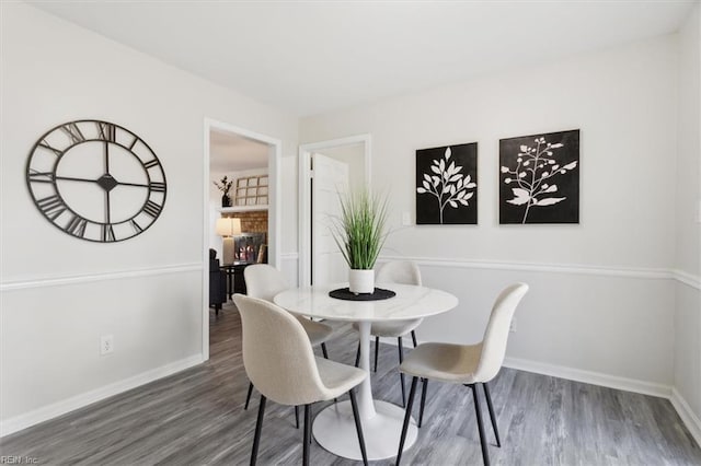 dining room featuring a fireplace and dark hardwood / wood-style floors