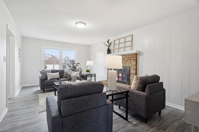 living room with dark wood-type flooring and a brick fireplace