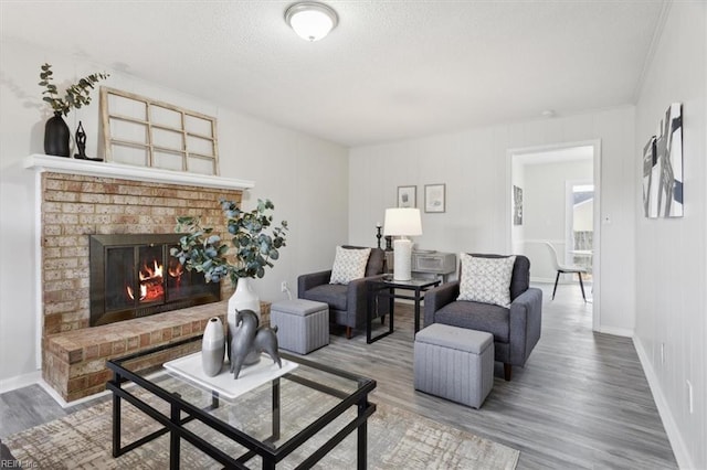 living room with a fireplace, hardwood / wood-style floors, and a textured ceiling