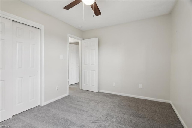 unfurnished bedroom featuring ceiling fan, light carpet, and a closet