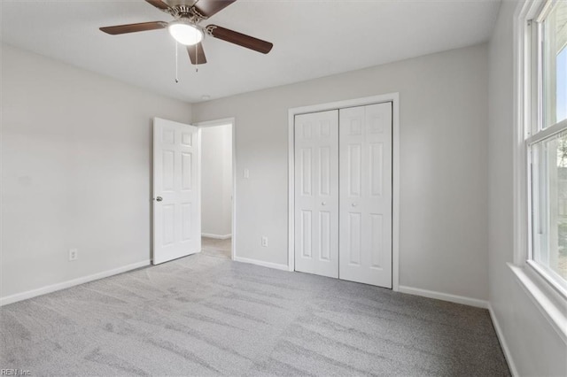 unfurnished bedroom with ceiling fan, a closet, and light carpet