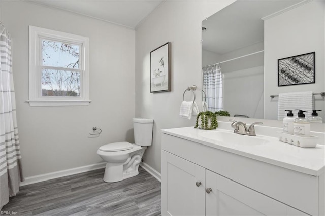 bathroom with vanity, toilet, wood-type flooring, and ornamental molding