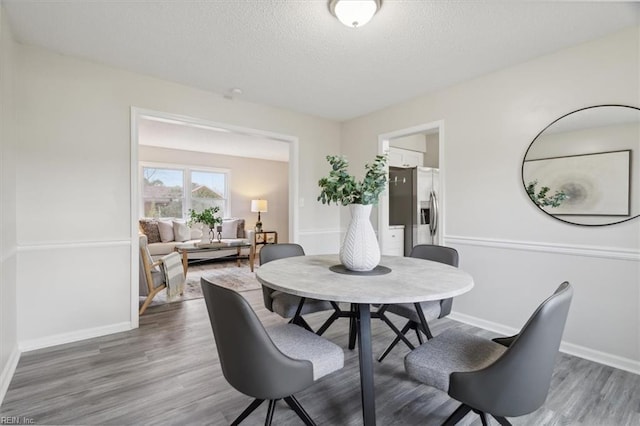 dining room with a textured ceiling and dark wood-type flooring