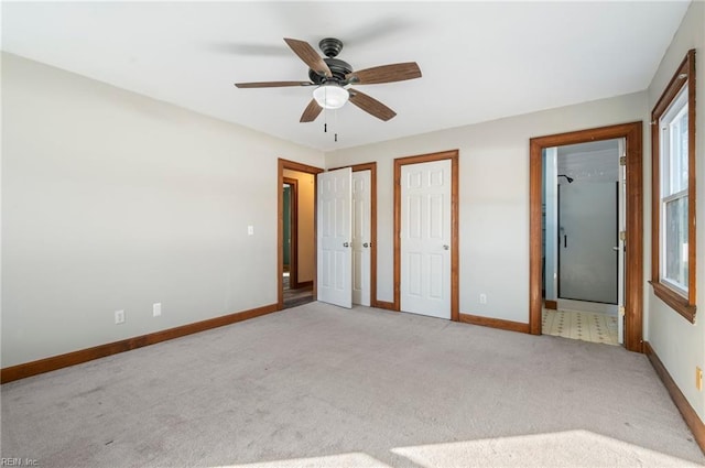 unfurnished bedroom featuring ceiling fan, light colored carpet, and connected bathroom