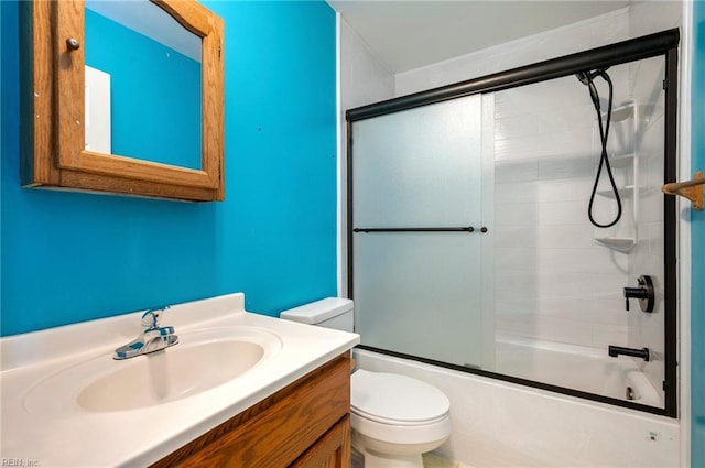 full bathroom featuring shower / bath combination with glass door, vanity, and toilet