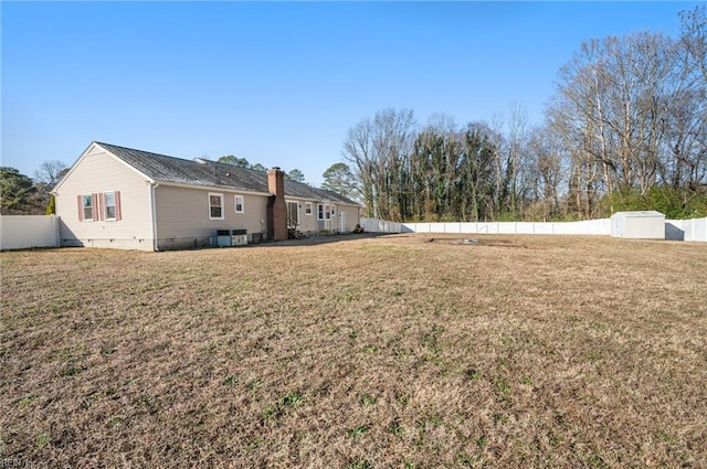 view of yard with central AC and a storage shed