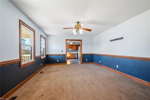 carpeted empty room featuring ceiling fan