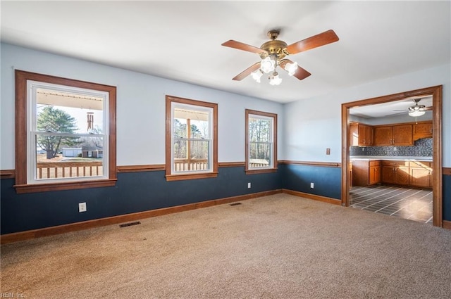 unfurnished bedroom with ceiling fan, carpet floors, and multiple windows