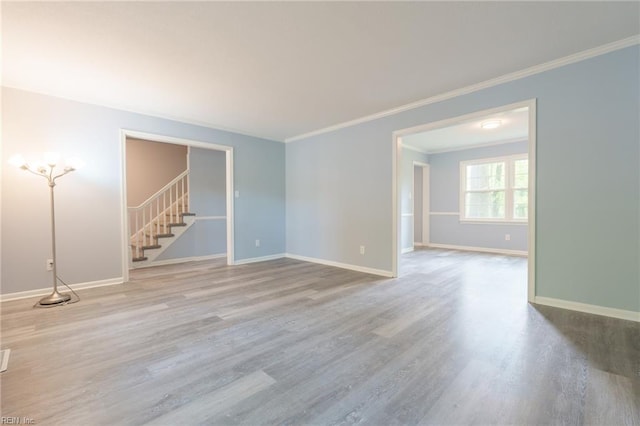 empty room featuring light hardwood / wood-style floors and ornamental molding