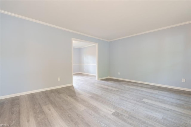 spare room featuring light hardwood / wood-style floors and crown molding