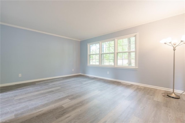 spare room featuring hardwood / wood-style floors and ornamental molding