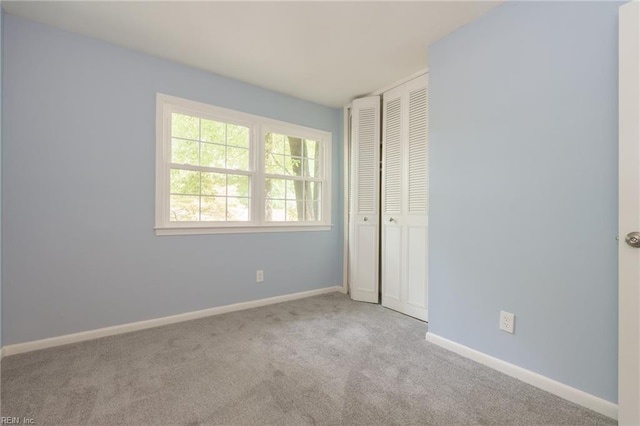 unfurnished bedroom featuring a closet and light colored carpet