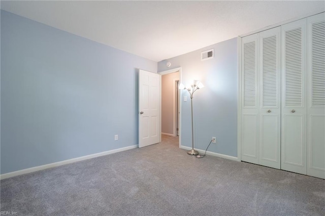 unfurnished bedroom with light carpet and a closet