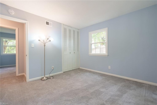 unfurnished bedroom featuring light carpet and a closet