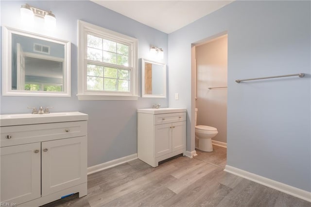 bathroom with hardwood / wood-style floors, vanity, and toilet