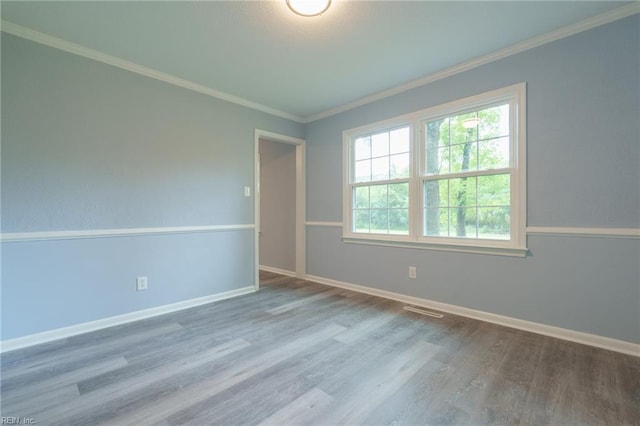 unfurnished room featuring wood-type flooring and ornamental molding